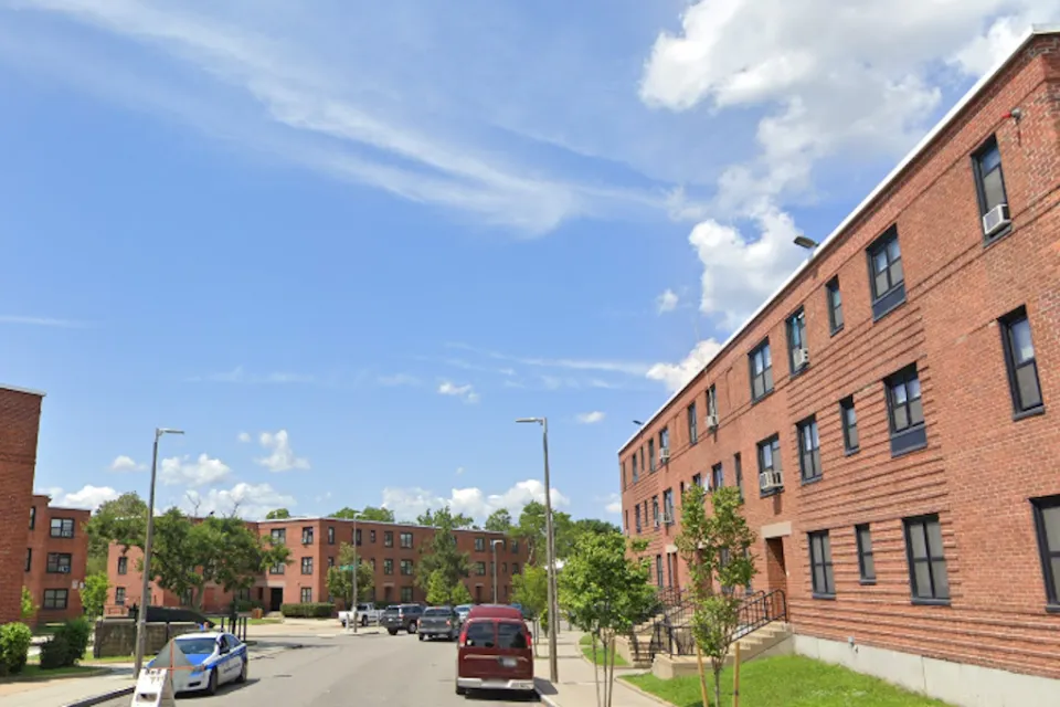 Google street view of brick three-story public housing buildings in Dorchester, MA.
